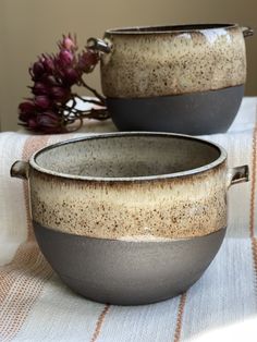 two gray and white bowls sitting on top of a table