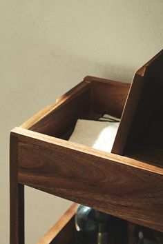 a wooden shelf with wine bottles in it and a towel on the bottom one side