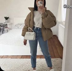 a woman taking a selfie with her cell phone in front of her face while standing on a carpeted floor