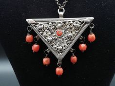 1900's Ottoman Turkish silver triangle amulet necklace decorated with fligree and coral beads. It has a sliding lid (#4). Back side is marked by its master in Ottoman (#5). *        overall length 39cm (15.3/8")    -   necklace 4.5cm by 4.5cm (1.3/4" by 1.3/4")    -    29g Solid and in very good condition for age with some wear of use. (see all picts as complementary information to the item description) Collectable Amulet Necklace, Coral Beads, Pendant Necklaces, Antique Silver, Jewelry Necklace Pendant, Coral, Accessory Gift, Jewelry Necklaces, Electronic Accessories