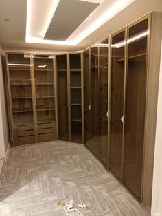 an empty walk in closet with glass doors and no shoes on the floor next to it