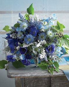 a bouquet of blue flowers sitting on top of a wooden table