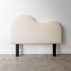 a white headboard sitting on top of a cement floor