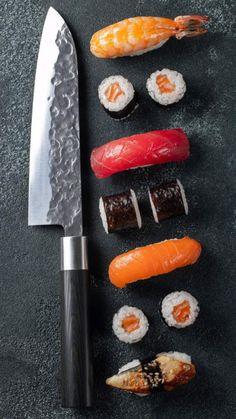 an assortment of sushi on a black surface