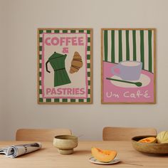 two framed pictures hang on the wall above a dining room table with fruit and coffee