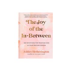 the joy of the in - between book cover with pink watercolors and gold lettering