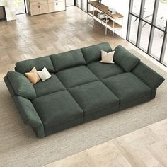 a green couch sitting on top of a hard wood floor