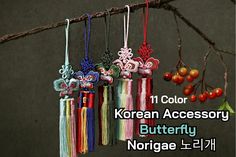 an assortment of korean accessories hanging from a tree branch with berries in the foreground