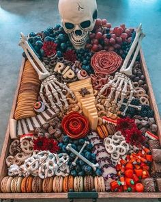 a tray filled with lots of different types of food and a skull on top of it