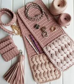 a crocheted purse with yarn, scissors and other items laid out on the table