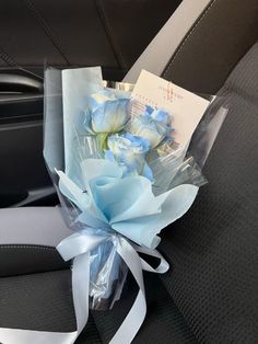 a bouquet of flowers sitting in the back seat of a car with a note attached to it