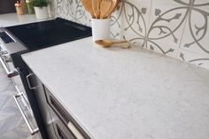 a kitchen counter with utensils on it next to an oven and stove top