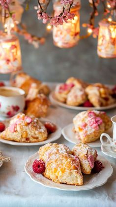 pastries are on plates with raspberries and powdered sugar