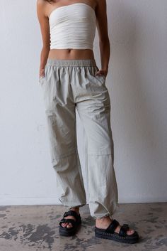 The cargo is back and so is low rise? That's right, this trend is sticking around and we are in obsessed! Color: Grey Mist Loose Fit Elastic Waist Pockets Drawstring Ankle Relaxed Leg Nylon Model is 5'9", size 24 in bottoms and is wearing medium Loosely Fitted Parachute Pants With Cargo Pockets For Loungewear, Relaxed Fit Linen Cargo Bottoms, Sporty Bottoms With Cargo Pockets For Everyday, Relaxed Fit Linen Cargo Style Bottoms, Linen Cargo-style Bottoms, Everyday Sporty Cargo Bottoms, Sporty Everyday Cargo Bottoms, Sporty Everyday Cargo Style Bottoms, Casual Mid-rise Cargo Pants For Summer