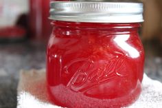 a red mason jar sitting on top of a white towel