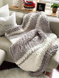 a white and gray blanket sitting on top of a couch