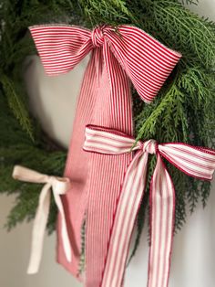 a christmas wreath with red and white striped bows