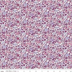 an abstract floral pattern in purple and white fabric with small flowers on the bottom half of it