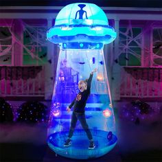 a young boy standing on top of a blue and purple lit inflatable object