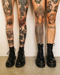 two women with tattoos standing next to each other and their legs are covered in tattoos