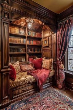 an old library with lots of bookshelves and pillows on the couch in front of it