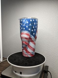 a plastic cup with an american flag design on it sitting on top of a record player