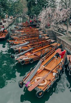 many small wooden boats are docked in the water