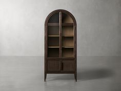 an arched wooden bookcase with glass doors on the front and bottom shelves in dark wood