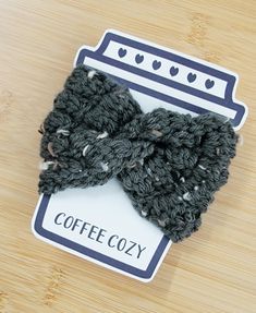 a crocheted bow tie sitting on top of a wooden table next to a card