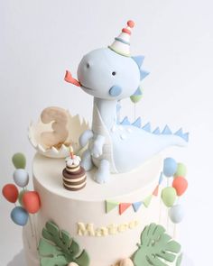 a birthday cake with a blue dinosaur on top