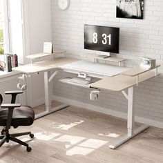 a computer desk with a monitor and keyboard on it in front of a brick wall