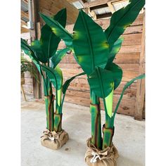 two large green planters sitting next to each other on top of a cement floor