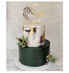 a white and green cake with gold decorations