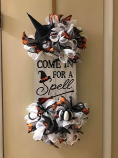 a sign that says come in for a spell on the front door with halloween decorations