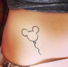 a small tattoo on the side of a woman's stomach, with images of mickey mouse