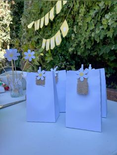 three bags with flowers on them sitting on a table