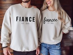 two people standing next to each other wearing sweatshirts that say france and est paris