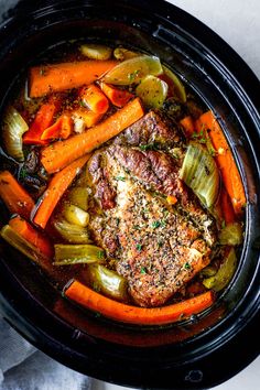 meat and vegetables in a slow cooker ready to be cooked for the dinner guests