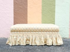 a bench sitting in front of a multi colored wall