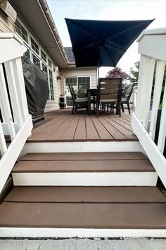 a deck with chairs and an umbrella on it