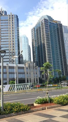 an empty street with tall buildings in the background