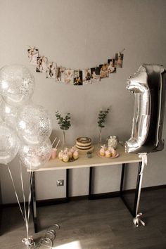 a table with balloons, cake and cupcakes on it