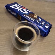 a bar of chocolate sitting on top of a table next to a cup of coffee