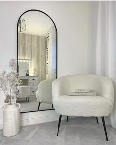 a white chair sitting in front of a large mirror