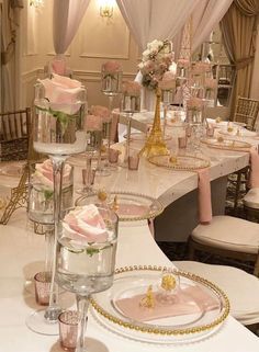 the tables are set with pink flowers and gold place settings for an elegant wedding reception