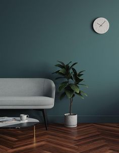 a living room with a couch, coffee table and clock on the wall