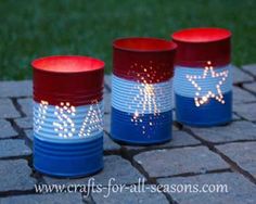 three red, white and blue plastic cups sitting on top of a brick floor next to grass