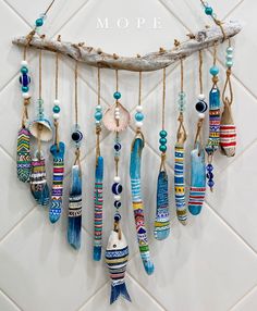 a group of beads hanging from a wooden branch on a tile wall with the words mop e written above it