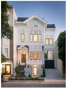 a large white house with many windows on it's sides and stairs leading up to the front door