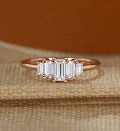 a three stone diamond ring sitting on top of a table